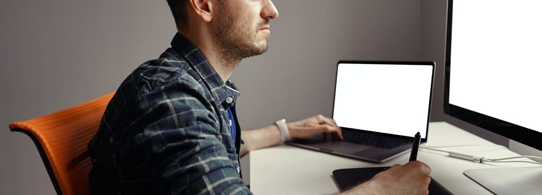 Young man working with interactive pen display and computer