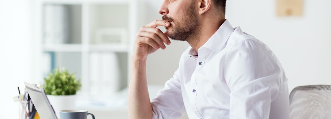 businessman with laptop thinking at office
