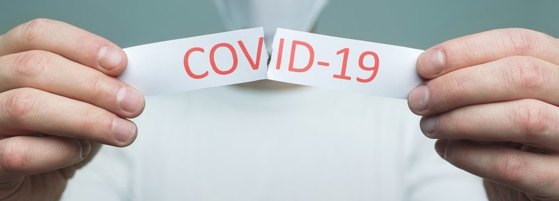 Man wearing a respiratory mask, holding the Coronavirus Covid-19 sign