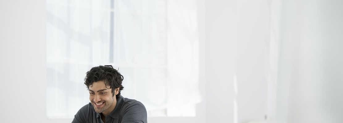 An office in the city. Business. A man sitting at a desk using a laptop.