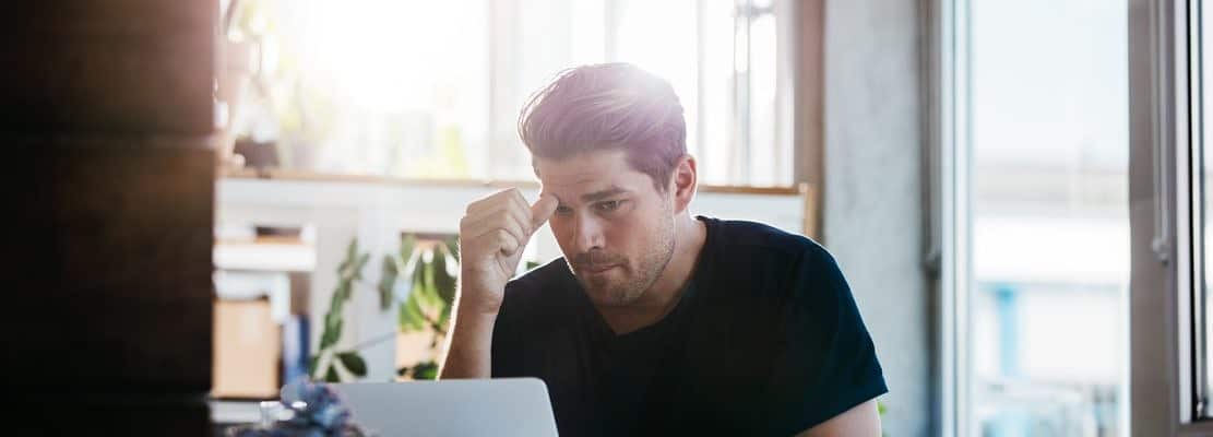 Business man thinking about a problem at his laptop