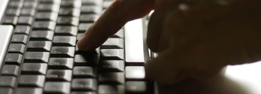 Using laptop, hands typing on the laptop keyboard