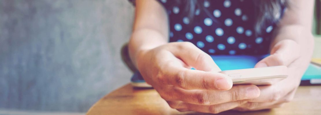 Close up hands of student using smartphone