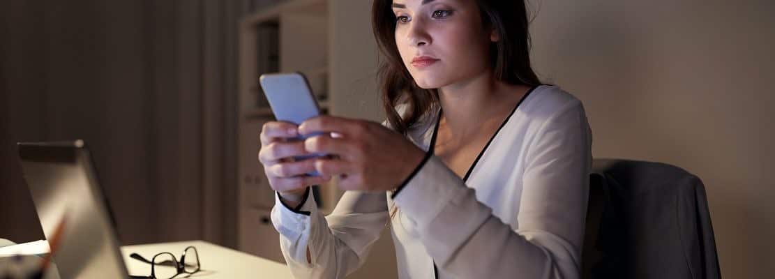 businesswoman with smartphone and laptop at office