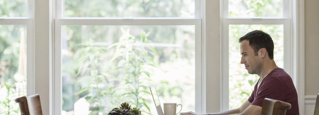 Caucasian businessman working from home using his laptop computer.