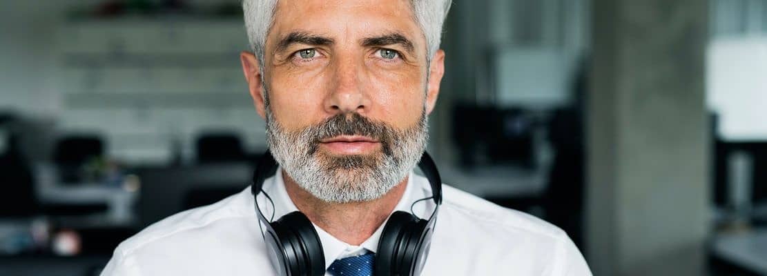 Mature businessman with headphones in the office.