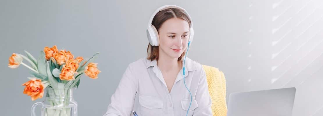 Busy Caucasian business woman in headphones working studying on laptop from home office.