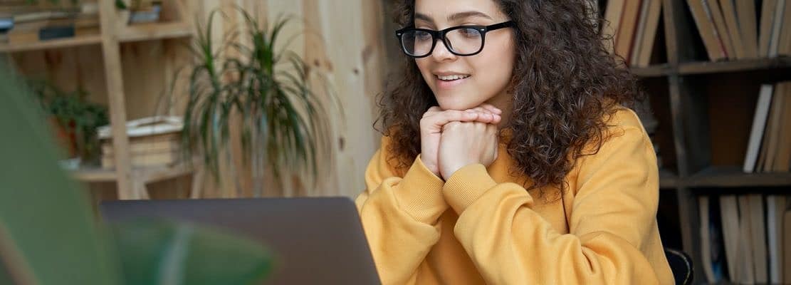 Hispanic teenage girl student watching online education webinar on laptop.