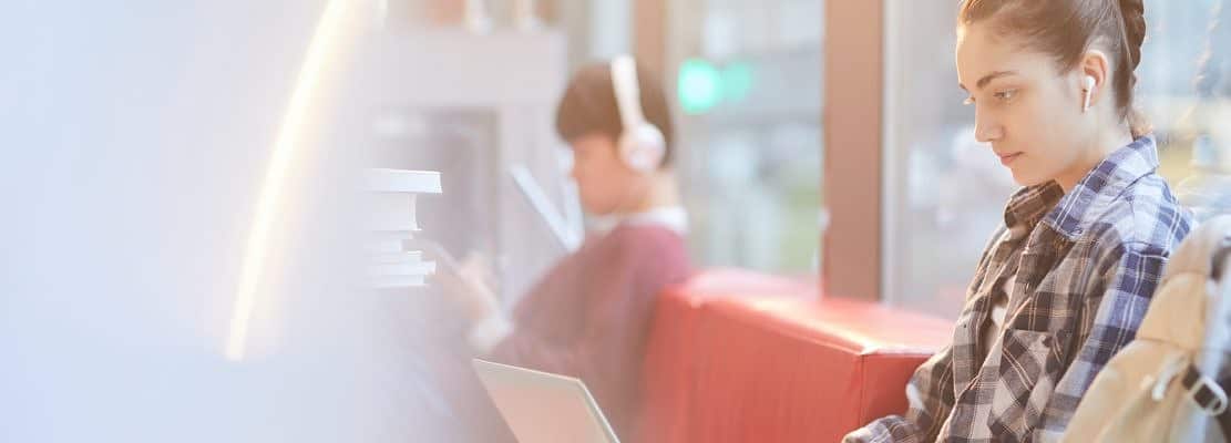 Teenage girl typing on laptop