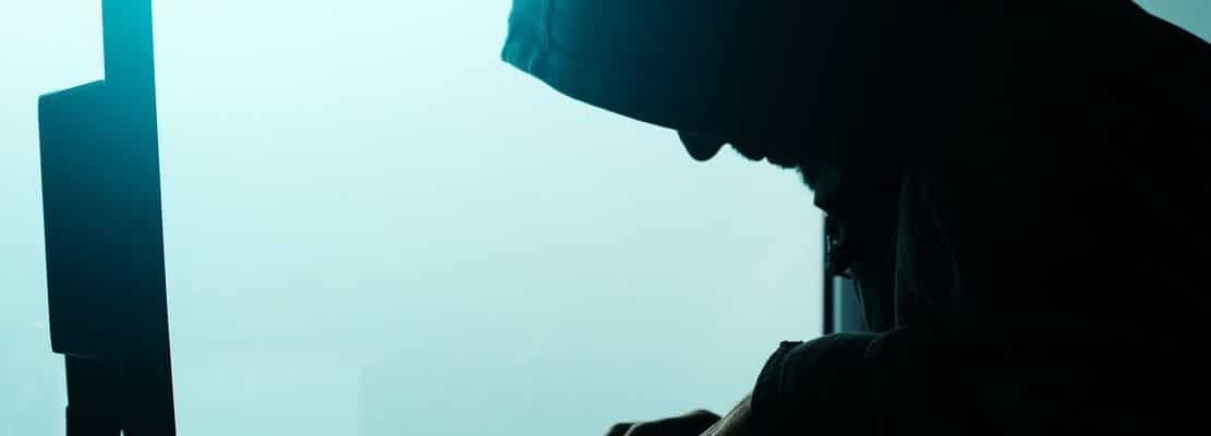 Hooded computer hacker hacking network
