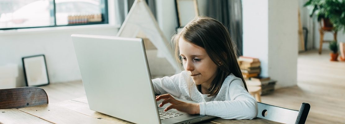 A girl learns at home at the computer