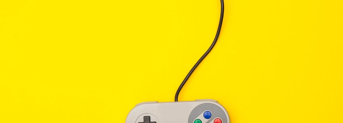 Retro computer gaming controller on a yellow background