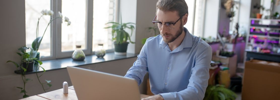 Young man working on laptop in office.