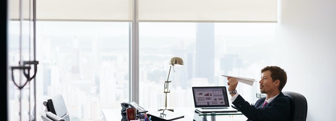 Bored Business Man Throwing Paper Airplane In Office