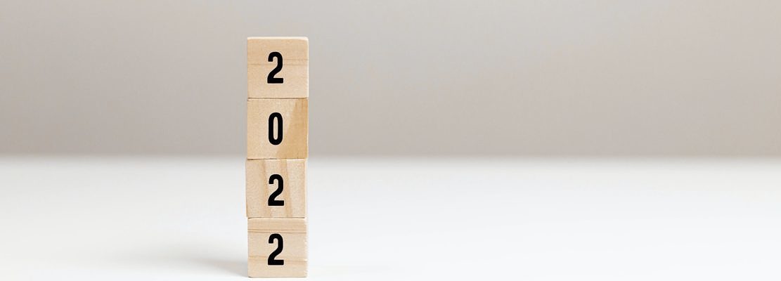 Wooden blocks with message 2022 Number on white table on light background. New Year's composition