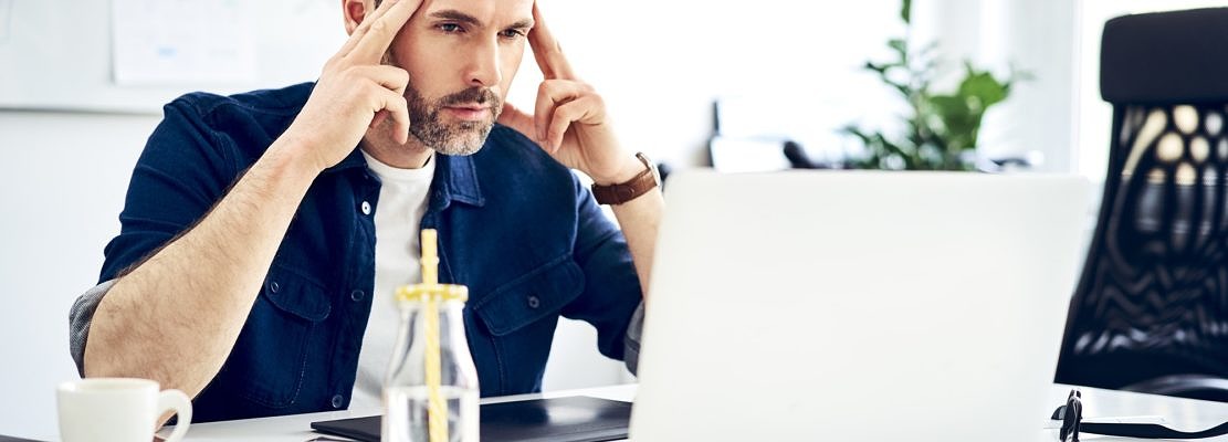 Focused businessman working on laptop at desk in office