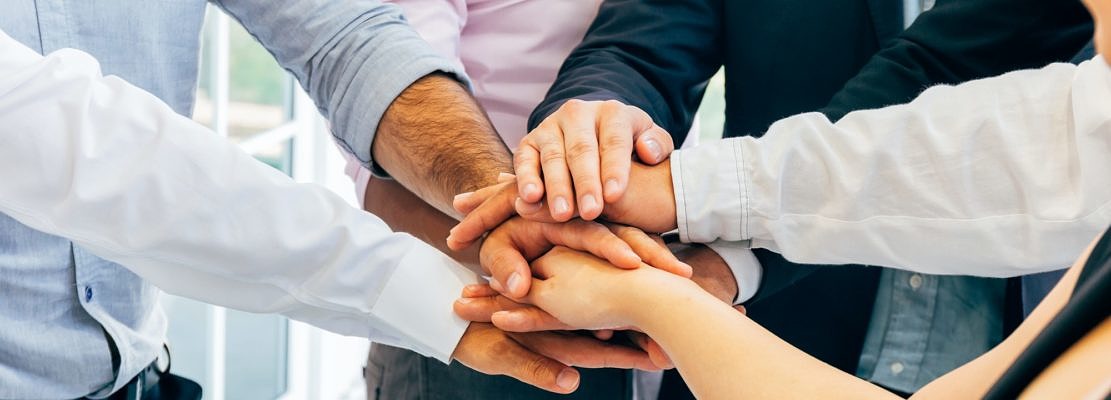 Business people putting hands togehter for unity