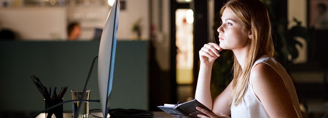 Businesswoman in her office at night working late.