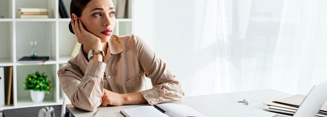 panoramic shot of bored businesswoman working with laptop in modern office