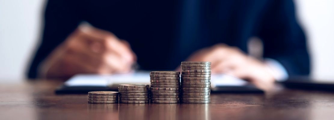 Coin to stack money, financial Business Growth. Men background is signing documents.
