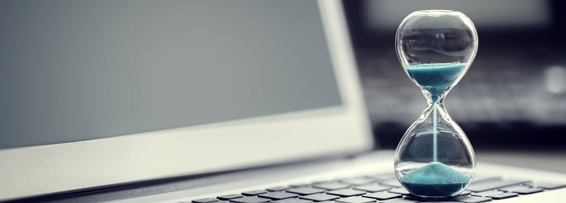 Hourglass on laptop computer concept for time management