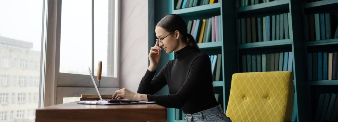 A female designer works in an office, uses a laptop computer workplace coworking space
