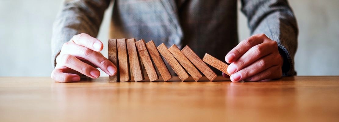 Closeup image of a businessman try to holding wooden block while falling for business concept