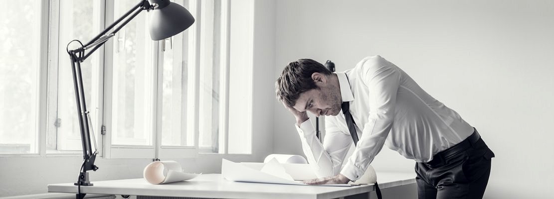 Frustrated business man analyzing plans