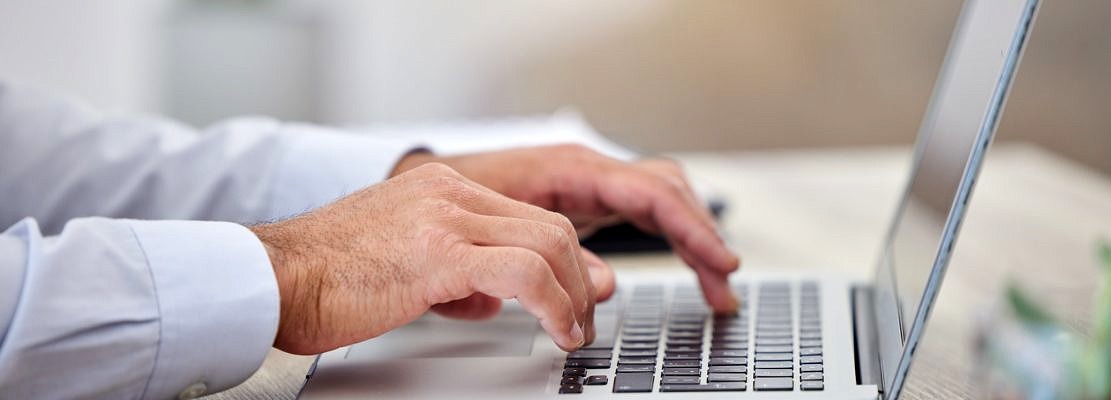 Hand, laptop and research with the hands of a business man typing an email on a keyboard in the off