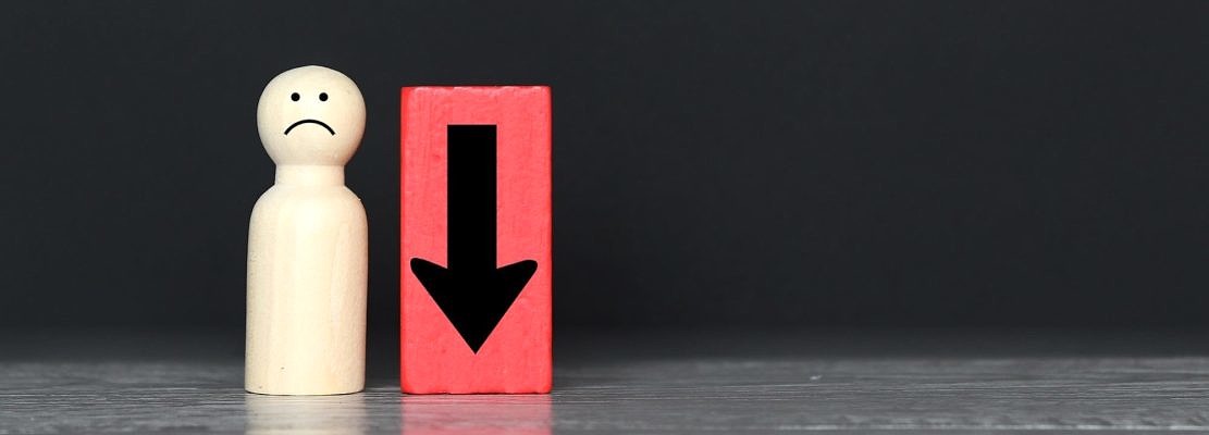 Wooden doll and downward arrow with copy space.