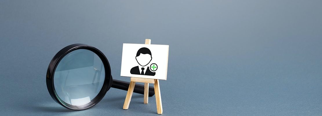Magnifying glass and an easel with a new hired employee.