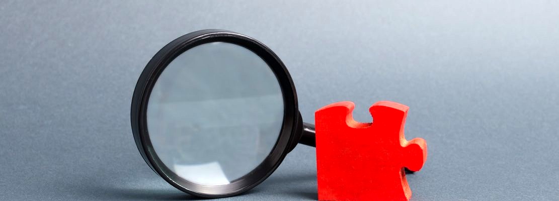 Red puzzle and magnifying glass