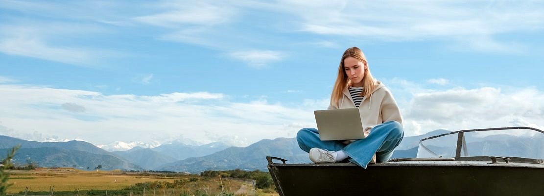 Remote work.Girl freelancer works remotely on the sea shore. workation, remote work,WFVH,Van Life vi