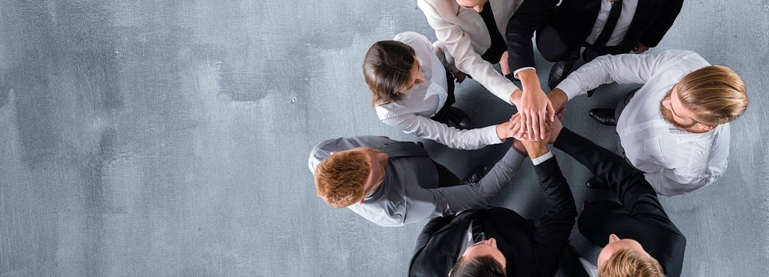 Handshaking business person in office. Concept of teamwork and partnership.