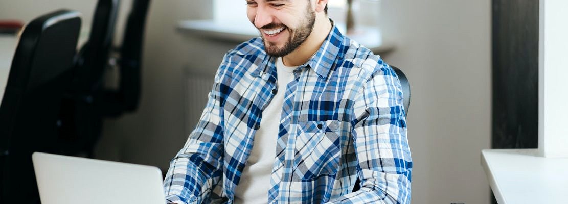 Happy man working on laptop
