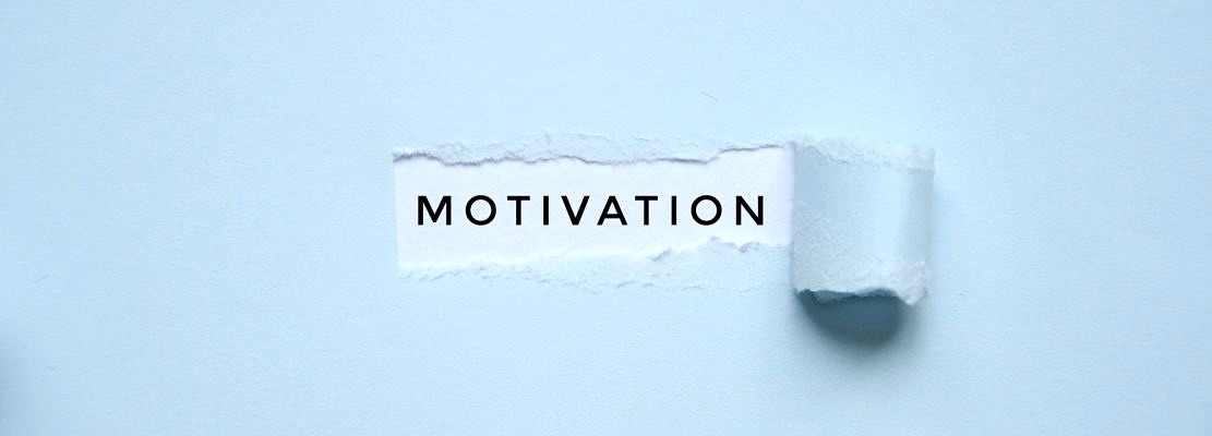 Overhead photo of a light blue paper with a hole where it says motivation