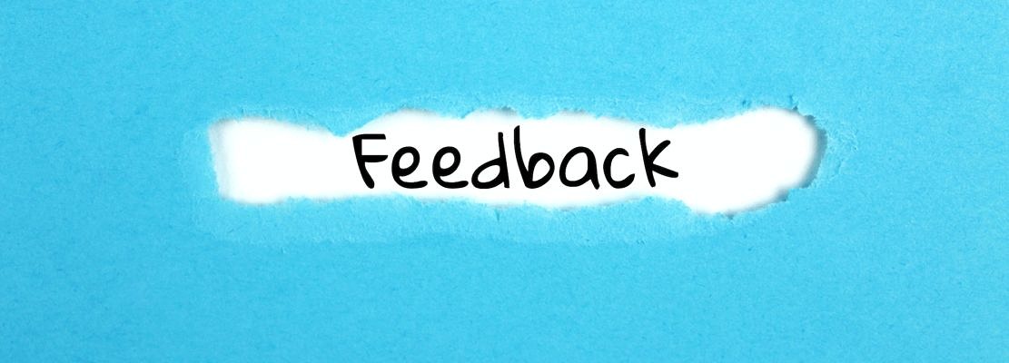 a torn paper written with inscription feedback on a blue background