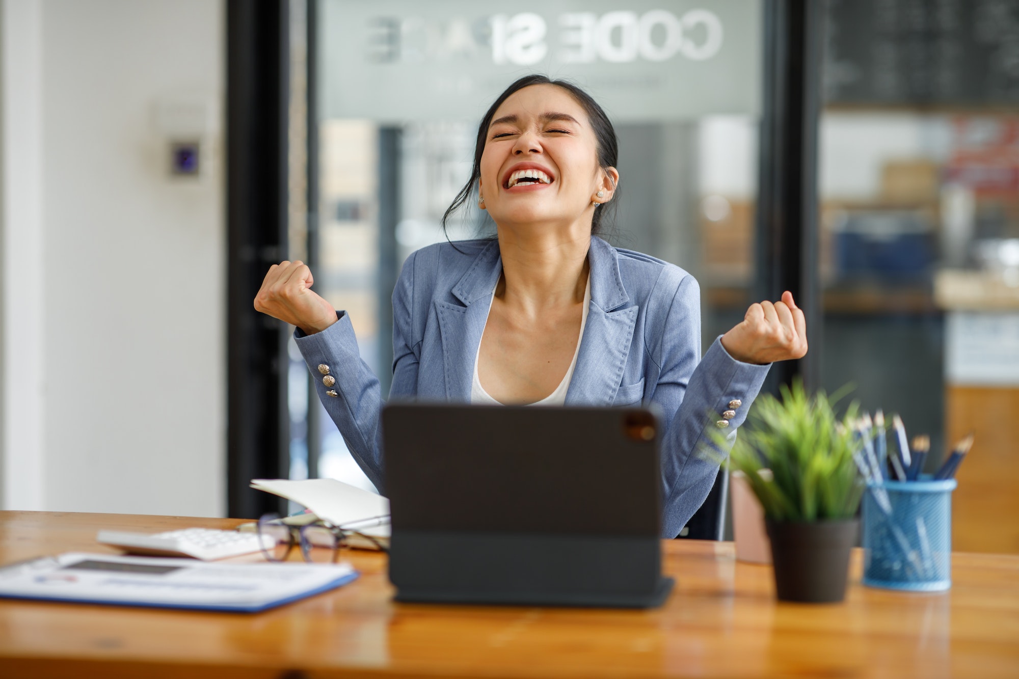 Excited executive receiving good news online sitting in a coffee shop, Business Success. Asian Busin Excited executive receiving good news online sitting in a coffee shop, Business Success. Asian Busin