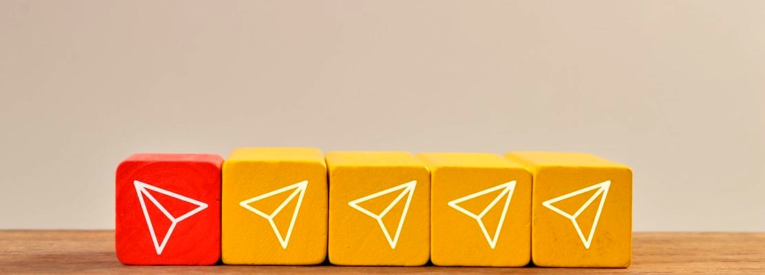 Red wooden block with plane icon turn to different way from the group. Innovation and new idea.