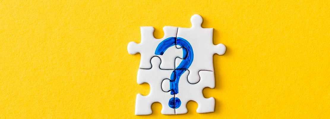 top view of connected puzzle pieces with drawn blue question mark on yellow