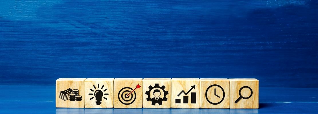 Wooden blocks depicting business strategy icons.