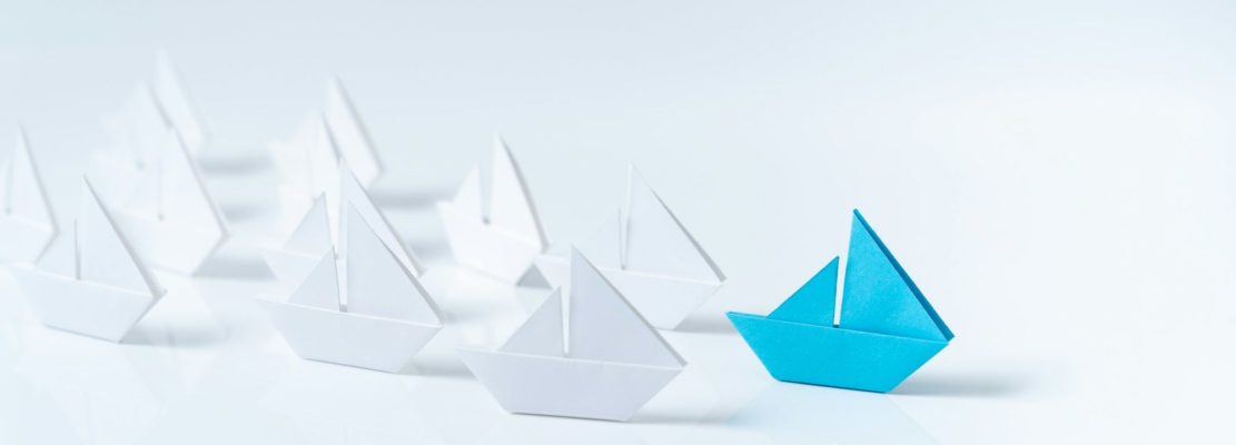 Leadership conceptual using blue paper ship