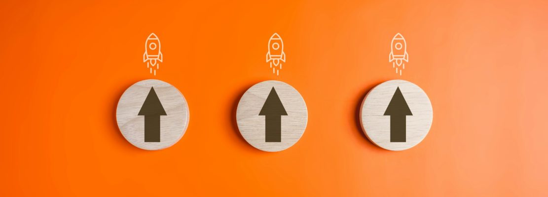 Arrow up sign and rocket icon on wooden blocks