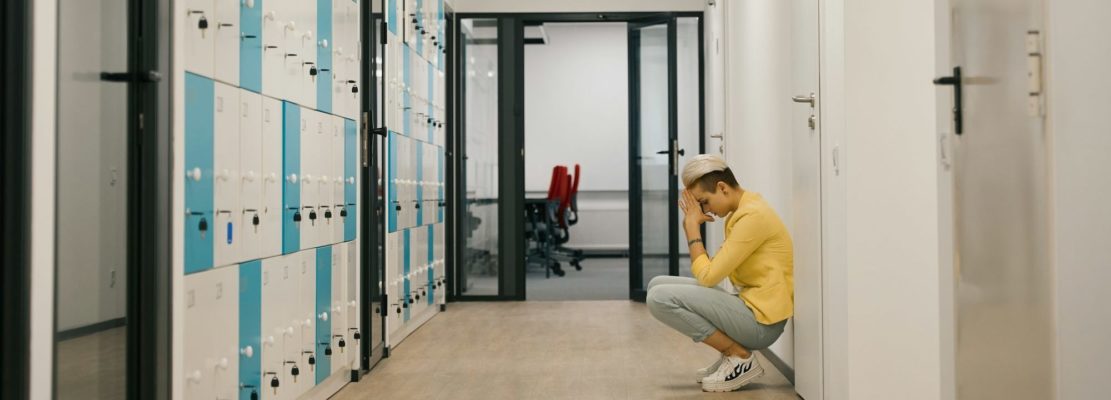 Woman crying in corridor of coworking office