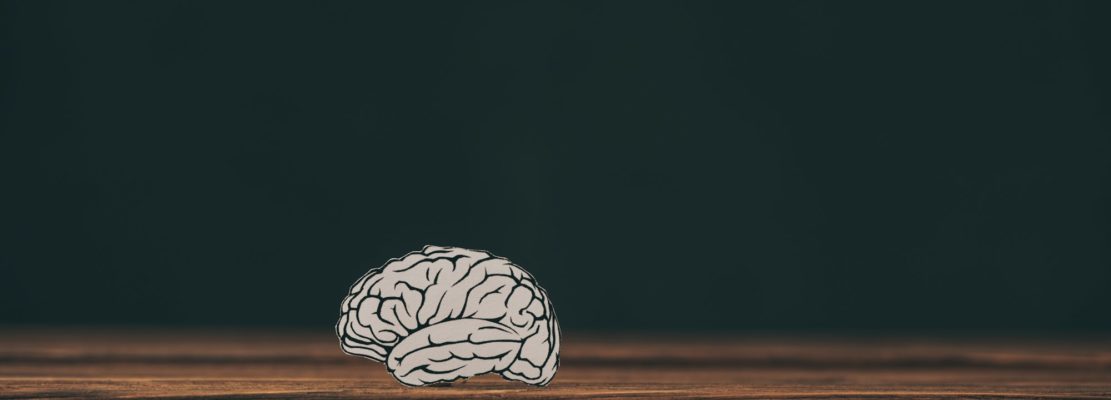 paper with brain shape as dementia symbol on black background