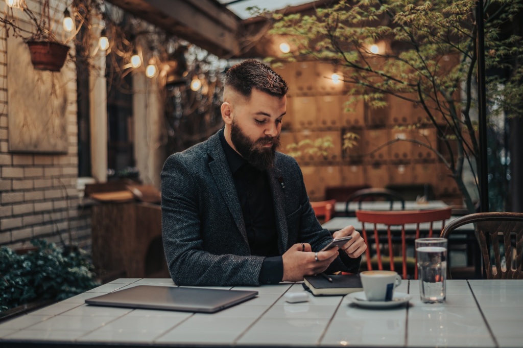 Wie kann Nano-Learning die Aufmerksamkeitsspanne erhöhen und die Kompetenzentwicklung unterstützen? 2 Businessman using smartphone in a cafe