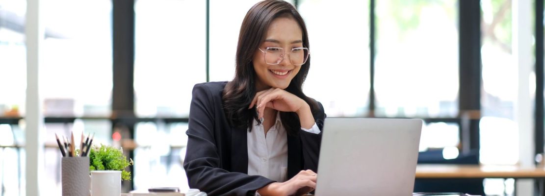 Young Asian businesswoman is happy to work at the modern office using a tablet.