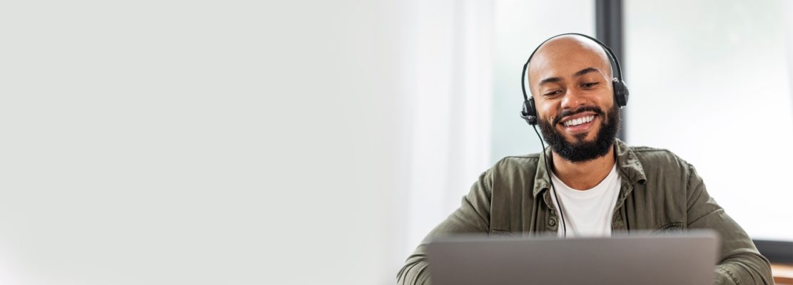 Man with headphones working on laptop at office