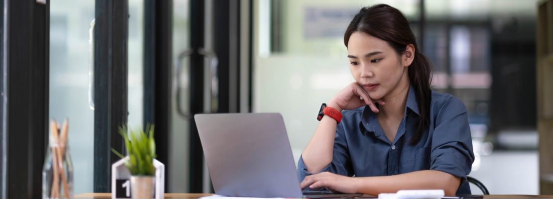 Portrait of Asian young female working on laptop at office