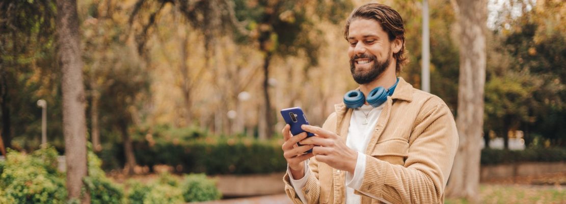 z gen caucasian man using cellphone in park